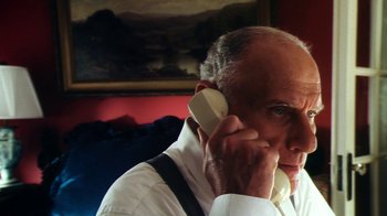 Movie still from “Forces of Nature” (1999), directed by Bronwen Hughes – An older man talking on a cell phone while sitting down; Close Up shot, Low angle