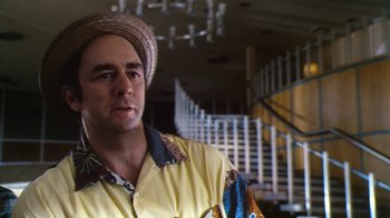 Movie still from “Forces of Nature” (1999), directed by Bronwen Hughes – A man wearing a hat standing in front of a staircase; Close Up shot, Low angle