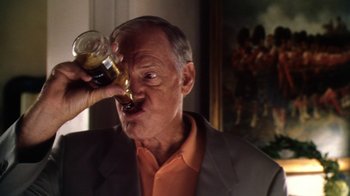 Movie still from “Forces of Nature” (1999), directed by Bronwen Hughes – An older man drinking a glass of beer; Close Up shot, Overhead angle