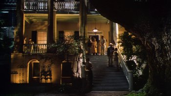 Movie still from “Forces of Nature” (1999), directed by Bronwen Hughes – A group of people standing on the steps of a house; Extreme Wide shot, Low angle
