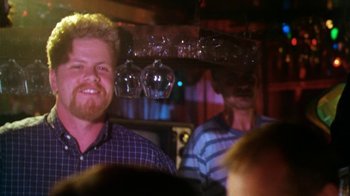Movie still from “Forces of Nature” (1999), directed by Bronwen Hughes – A man with a goatee and a checkered shirt is smiling; Close Up shot, Over the shoulder angle