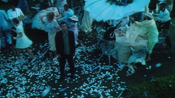Movie still from “Forces of Nature” (1999), directed by Bronwen Hughes – A man in a suit standing in front of an umbrella; Wide shot, High angle