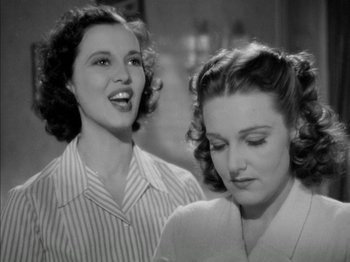 Movie still from “Four Daughters” (1938), directed by Michael Curtiz – Two beautiful women standing next to each other in a room; Close Up shot, Low angle