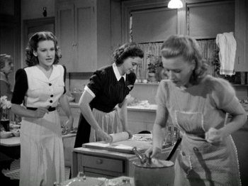 Movie still from “Four Daughters” (1938), directed by Michael Curtiz – A group of women standing in a kitchen preparing a meal; Medium shot, Low angle