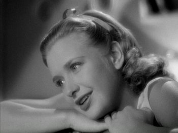 Movie still from “Four Daughters” (1938), directed by Michael Curtiz – A young woman is posing for a picture; Close Up shot, High angle