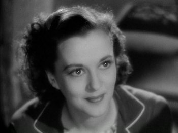 Movie still from “Four Daughters” (1938), directed by Michael Curtiz – An old photo of a woman in a black and white photo; Close Up shot, High angle