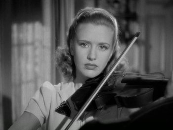 Movie still from “Four Daughters” (1938), directed by Michael Curtiz – A woman is holding a violin and looking at the camera; Close Up shot, Low angle