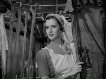 Movie still from “Four Daughters” (1938), directed by Michael Curtiz – A black and white photo of a woman holding a parasol; Medium shot, Low angle