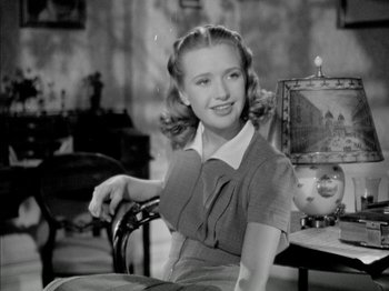Movie still from “Four Daughters” (1938), directed by Michael Curtiz – A woman sitting in a chair in front of a painting; Medium shot, Low angle