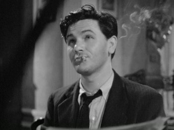 Movie still from “Four Daughters” (1938), directed by Michael Curtiz – A black and white photo of a man smoking a cigarette; Close Up shot, Low angle