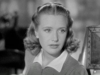 Movie still from “Four Daughters” (1938), directed by Michael Curtiz – A young woman in a sweater and a white shirt; Close Up shot, High angle