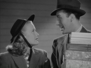 Movie still from “Four Daughters” (1938), directed by Michael Curtiz – A man and a woman wearing hats looking at each other; Medium shot, Low angle