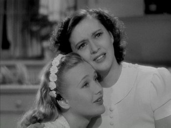 Movie still from “Four Daughters” (1938), directed by Michael Curtiz – A woman and a young girl posing for a picture; Close Up shot, Low angle