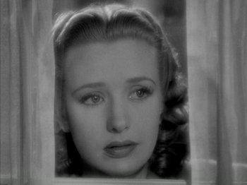 Movie still from “Four Daughters” (1938), directed by Michael Curtiz – A black - and - white photo of a woman looking through a window; Close Up shot, High angle