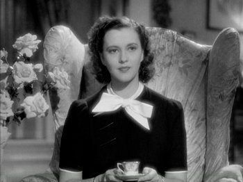 Movie still from “Four Daughters” (1938), directed by Michael Curtiz – A woman sitting in a chair holding a tea cup; Close Up shot, High angle