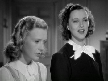Movie still from “Four Daughters” (1938), directed by Michael Curtiz – Two young women standing next to each other in a room; Close Up shot, Low angle