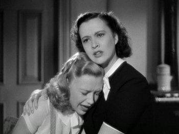 Movie still from “Four Daughters” (1938), directed by Michael Curtiz – Two women are hugging and one of them is crying; Medium shot, High angle