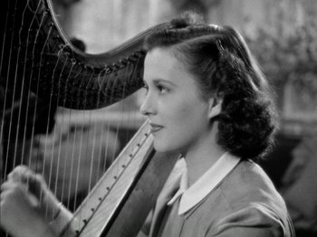 Movie still from “Four Daughters” (1938), directed by Michael Curtiz – A woman holding a harp in a black and white photo; Close Up shot, High angle