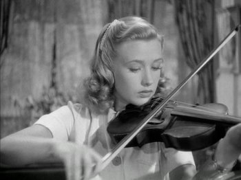Movie still from “Four Daughters” (1938), directed by Michael Curtiz – A young woman playing a violin in front of trees; Close Up shot, High angle