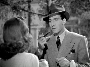 Movie still from “Four Daughters” (1938), directed by Michael Curtiz – An old photo of a man in a suit smoking a cigarette; Close Up shot, Over the shoulder angle