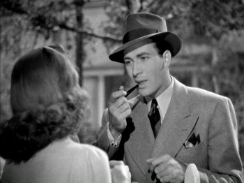 Movie still from “Four Daughters” (1938), directed by Michael Curtiz – A black and white photo of a man in a suit and tie; Close Up shot, High angle