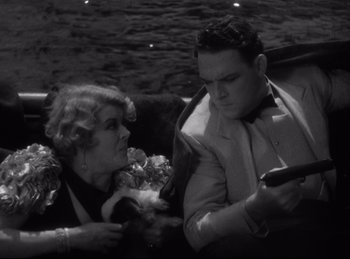 Movie still from “Four Frightened People” (1934), directed by Cecil B. DeMille – An old photo of a man and a woman sitting in a car; Medium shot, High angle