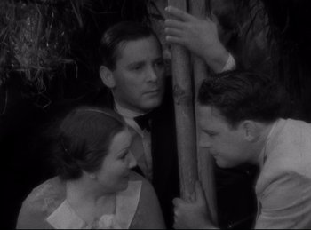 Movie still from “Four Frightened People” (1934), directed by Cecil B. DeMille – A group of people standing next to each other near a tree; Medium shot, High angle