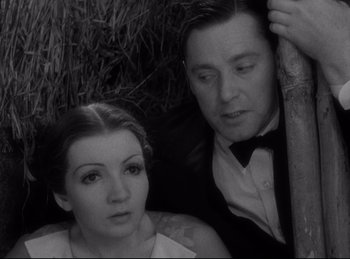 Movie still from “Four Frightened People” (1934), directed by Cecil B. DeMille – A man and a woman sitting next to each other; Close Up shot, High angle