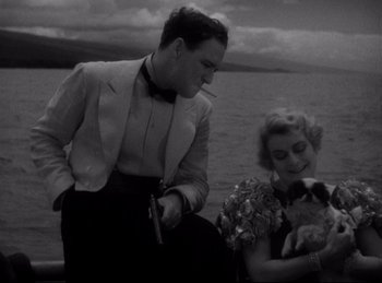 Movie still from “Four Frightened People” (1934), directed by Cecil B. DeMille – A man and a woman sitting next to each other on a boat; Medium shot, High angle
