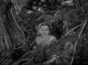 Movie still from “Four Frightened People” (1934), directed by Cecil B. DeMille – A black - and - white photo of a woman in the woods; Medium shot, High angle