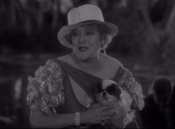 Movie still from “Four Frightened People” (1934), directed by Cecil B. DeMille – An older woman holding a small dog in her arms; Close Up shot, Low angle