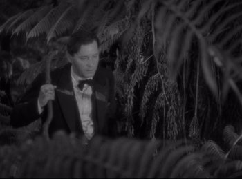 Movie still from “Four Frightened People” (1934), directed by Cecil B. DeMille – A black and white photo of a man in a tuxedo; Medium shot, High angle