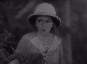Movie still from “Four Frightened People” (1934), directed by Cecil B. DeMille – A woman wearing a white hat and a white dress; Close Up shot, High angle