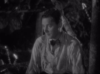 Movie still from “Four Frightened People” (1934), directed by Cecil B. DeMille – A black and white photo of a man in a tie; Close Up shot, High angle
