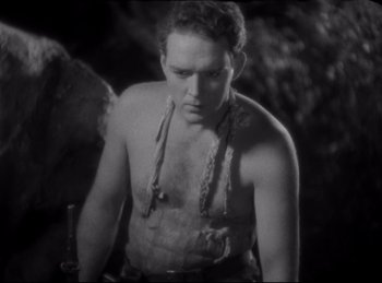 Movie still from “Four Frightened People” (1934), directed by Cecil B. DeMille – A black and white photo of a man with a knife in his hand; Medium shot, High angle