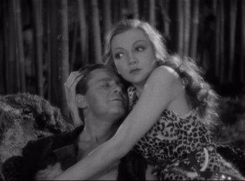 Movie still from “Four Frightened People” (1934), directed by Cecil B. DeMille – A man and a woman embracing each other in front of trees; Medium shot, High angle