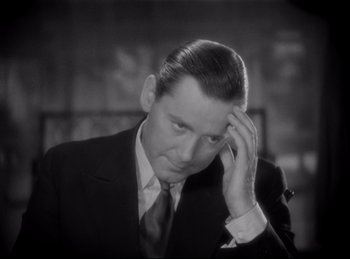 Movie still from “Four Frightened People” (1934), directed by Cecil B. DeMille – A man in a suit and tie holding his hand to his head; Close Up shot, High angle