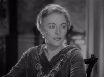 Movie still from “Four Frightened People” (1934), directed by Cecil B. DeMille – An old photo of an older woman sitting in a chair; Close Up shot, High angle