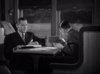 Movie still from “Four Frightened People” (1934), directed by Cecil B. DeMille – A man and a woman sitting at a table; Medium shot, High angle