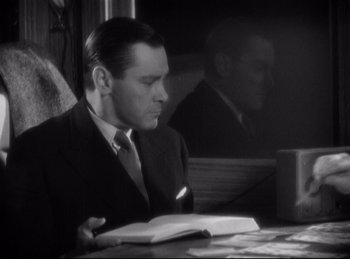 Movie still from “Four Frightened People” (1934), directed by Cecil B. DeMille – A black and white photo of a man reading a book; Medium shot, Low angle