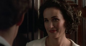 Movie still from “Four Weddings and a Funeral” (1994), directed by Mike Newell – A person wearing a suit and tie; Close Up shot, Over the shoulder angle