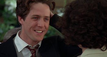 Movie still from “Four Weddings and a Funeral” (1994), directed by Mike Newell – A person touching a man's face; Close Up shot, Over the shoulder angle