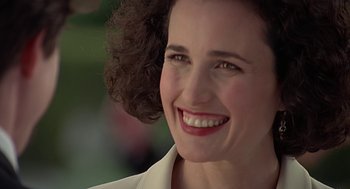 Movie still from “Four Weddings and a Funeral” (1994), directed by Mike Newell – A person with a smile on their face; Close Up shot, Over the shoulder angle