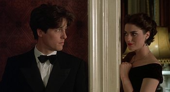 Movie still from “Four Weddings and a Funeral” (1994), directed by Mike Newell – A man and a woman standing next to each other in front of a mirror; Close Up shot, Over the shoulder angle