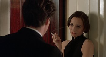 Movie still from “Four Weddings and a Funeral” (1994), directed by Mike Newell – A woman in a black dress looking in the mirror; Close Up shot, Over the shoulder angle