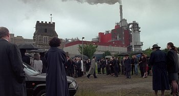 Movie still from “Four Weddings and a Funeral” (1994), directed by Mike Newell – A group of people standing in front of an industrial building; Extreme Wide shot, Over the shoulder angle