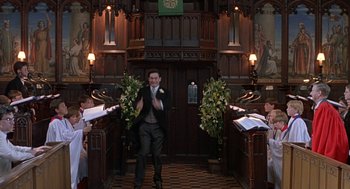 A man in a church holding a bouquet of flowers and clapping