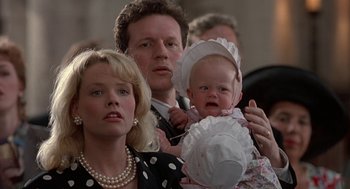 Movie still from “Four Weddings and a Funeral” (1994), directed by Mike Newell – A man and a woman holding a baby in her arms; Close Up shot, High angle