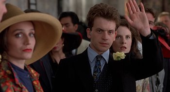 Movie still from “Four Weddings and a Funeral” (1994), directed by Mike Newell – A man in a suit and tie standing next to a woman in a suit; Close Up shot, Low angle