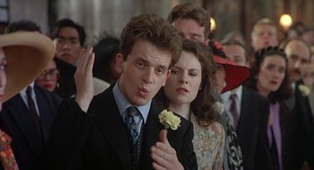 Movie still from “Four Weddings and a Funeral” (1994), directed by Mike Newell – A man and a woman standing next to each other in a crowd; Close Up shot, Low angle